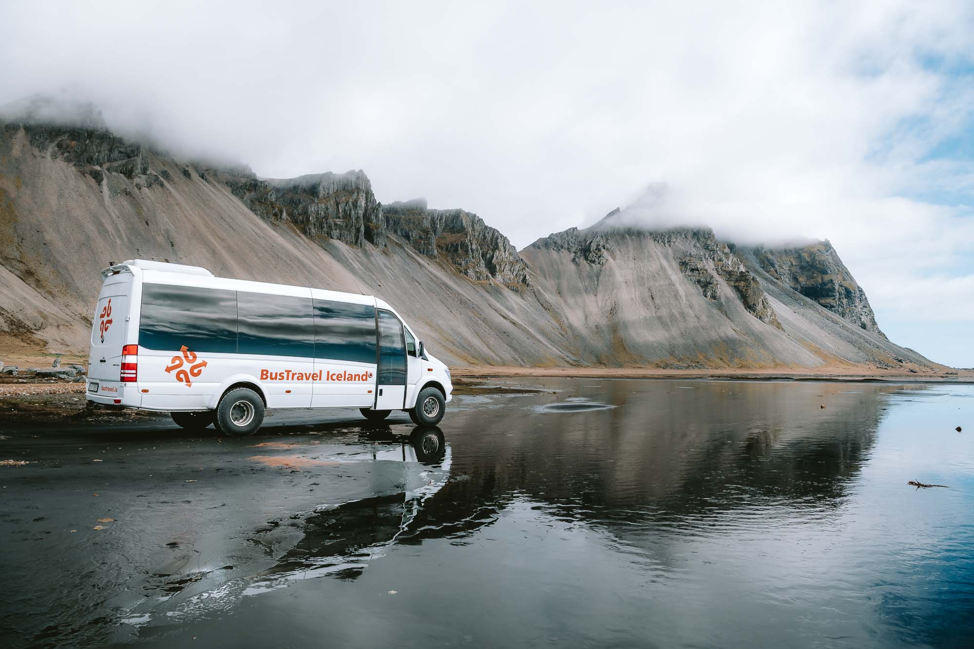 BusTravel Iceland tour bus on black sand beach, Iceland